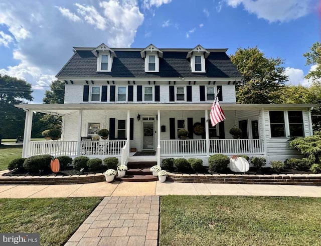 view of front of house with a porch and a front lawn