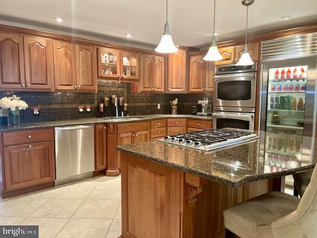 kitchen with a breakfast bar, tasteful backsplash, sink, stainless steel appliances, and light tile patterned floors