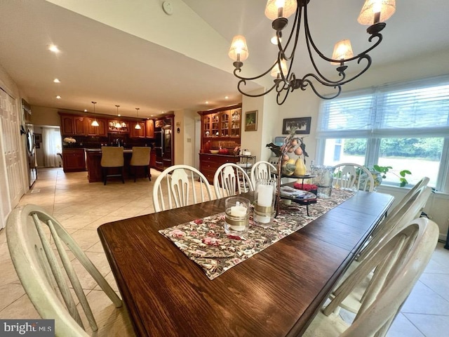 tiled dining room with an inviting chandelier