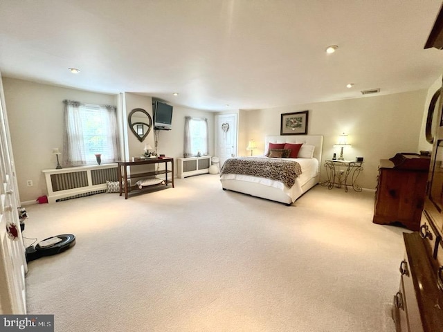 bedroom featuring radiator and light colored carpet