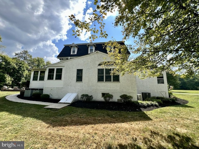 view of property exterior featuring a lawn and central air condition unit