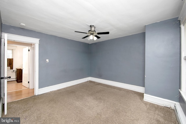 empty room featuring carpet floors, a baseboard heating unit, and ceiling fan