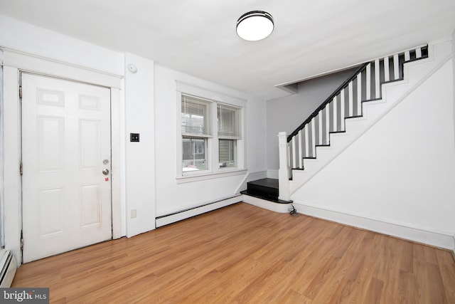 foyer with light wood-type flooring and a baseboard heating unit