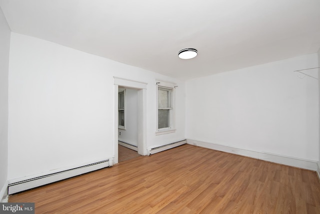 unfurnished room featuring light hardwood / wood-style flooring and a baseboard heating unit