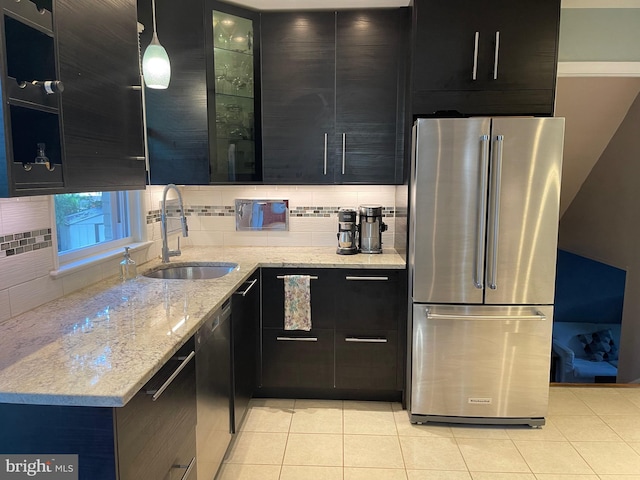 kitchen featuring light stone counters, pendant lighting, light tile patterned flooring, sink, and high end fridge