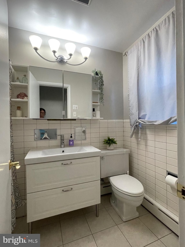 bathroom featuring vanity, a baseboard heating unit, tile patterned floors, tile walls, and toilet