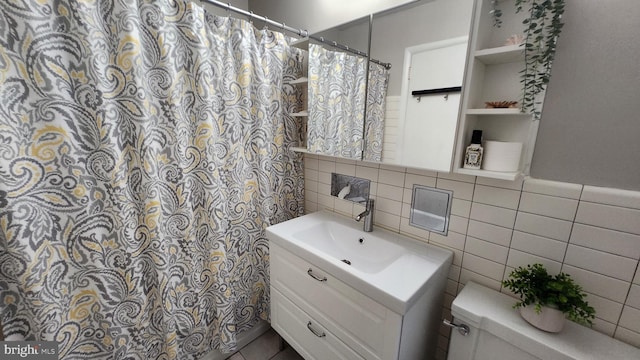 bathroom featuring walk in shower, tile walls, vanity, and toilet