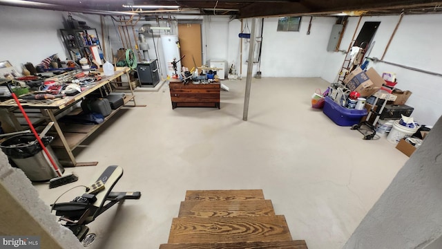 basement featuring gas water heater, a workshop area, and electric panel