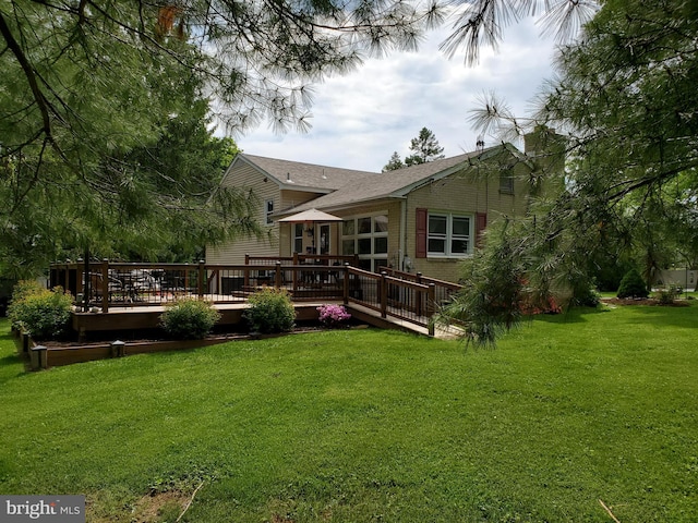 back of property featuring a deck and a yard