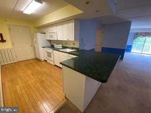 kitchen featuring white cabinets, white appliances, kitchen peninsula, and light hardwood / wood-style floors