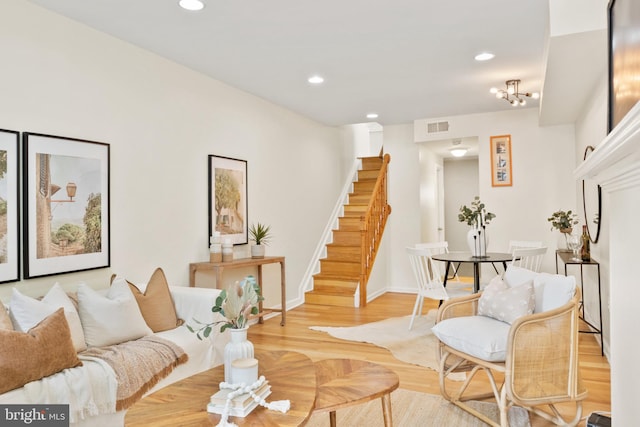 living room featuring light wood-type flooring and a notable chandelier