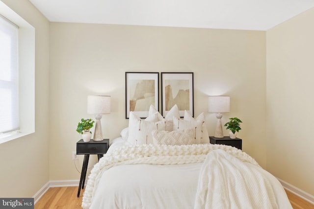 bedroom featuring multiple windows and light hardwood / wood-style flooring