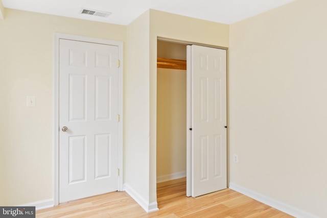 unfurnished bedroom with wood-type flooring and a closet