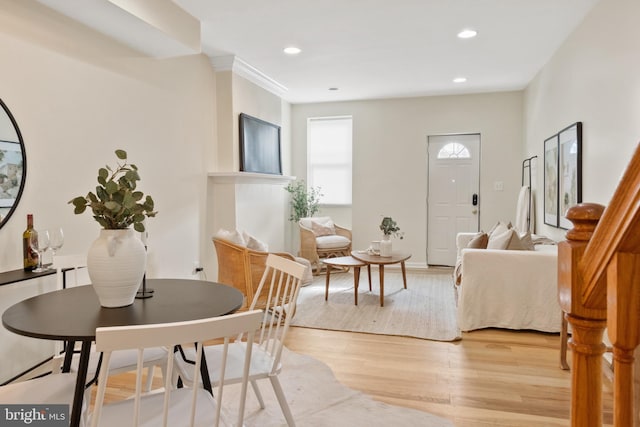 dining space featuring light hardwood / wood-style flooring and crown molding