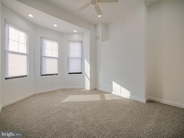 carpeted spare room featuring ceiling fan