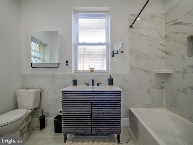 full bathroom with tile walls, vanity, tiled shower / bath combo, and toilet