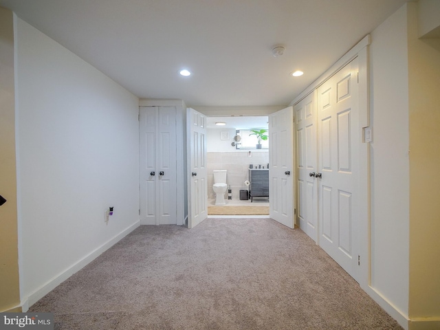 interior space featuring light carpet and connected bathroom