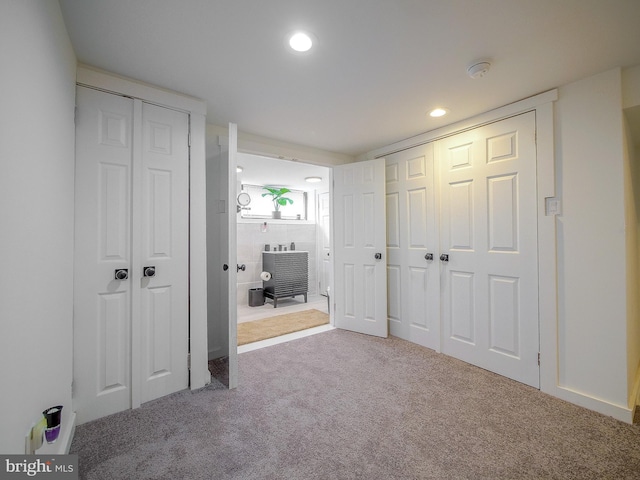 unfurnished bedroom featuring carpet and multiple closets