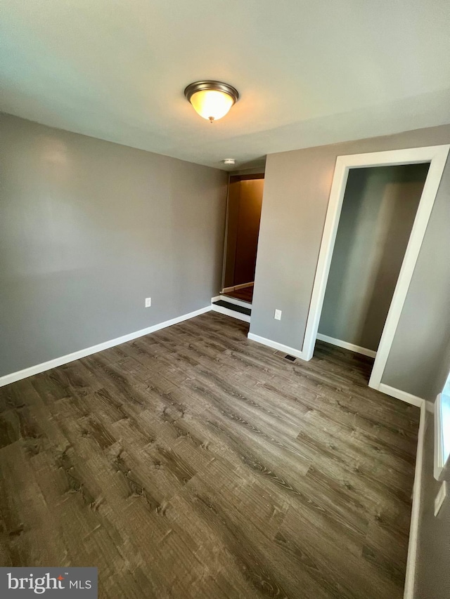 unfurnished bedroom with dark hardwood / wood-style floors and a closet