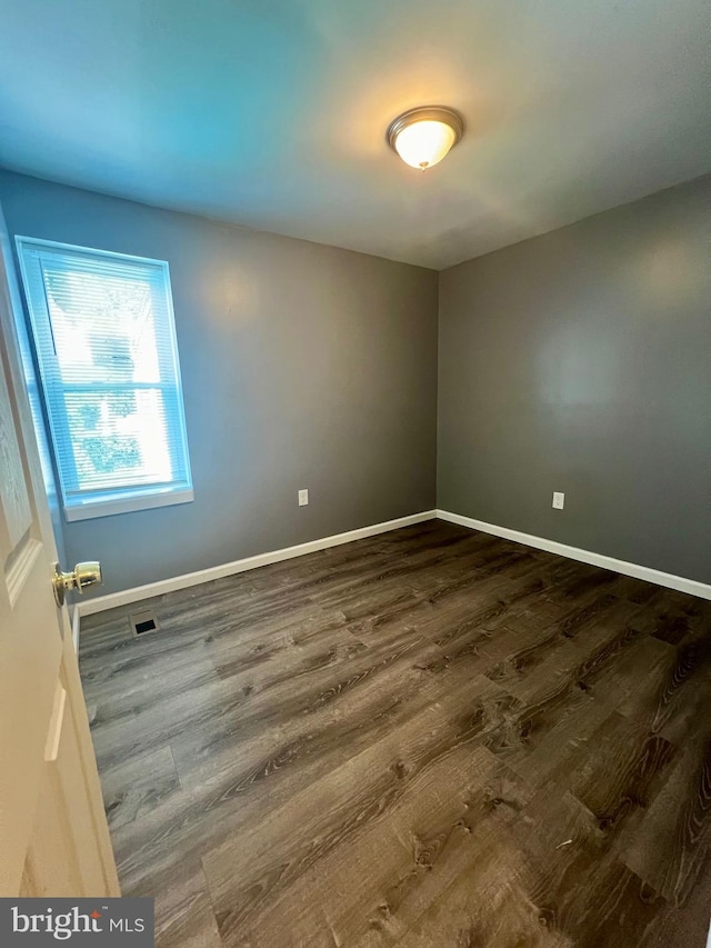 unfurnished room with dark hardwood / wood-style floors