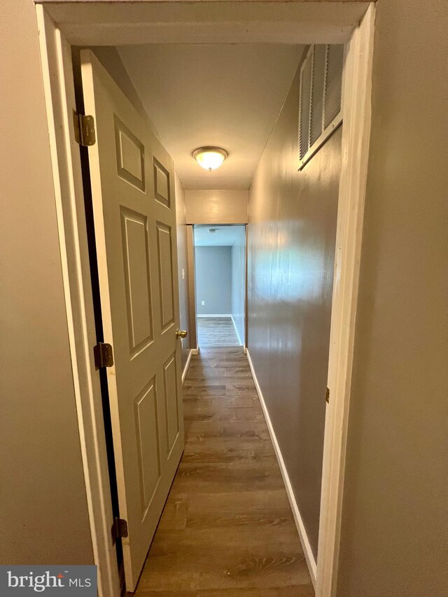 corridor with hardwood / wood-style flooring