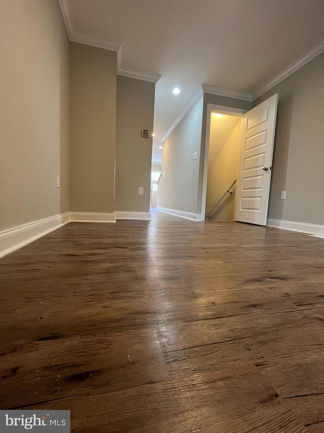 spare room featuring ornamental molding and dark wood-type flooring