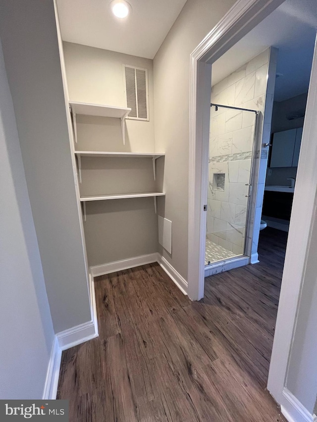 interior space featuring wood-type flooring and an enclosed shower