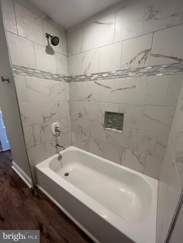 bathroom with wood-type flooring and tiled shower / bath