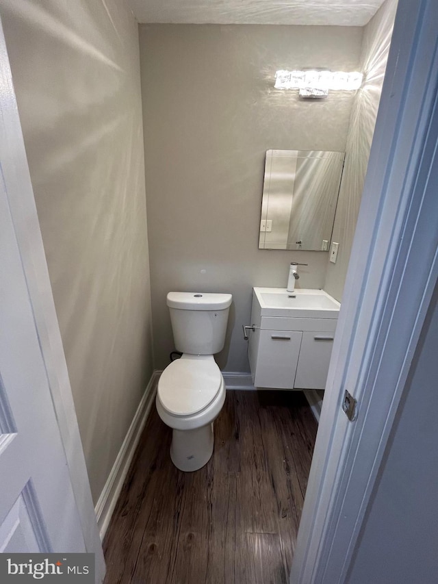 bathroom featuring vanity, wood-type flooring, and toilet