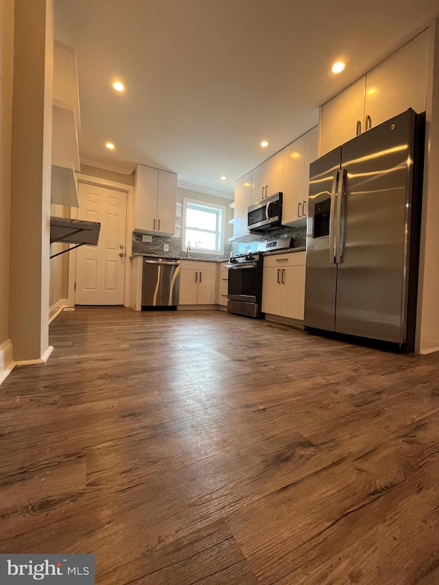 kitchen featuring white cabinets, dark hardwood / wood-style floors, appliances with stainless steel finishes, and tasteful backsplash