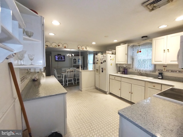 kitchen with white fridge with ice dispenser, sink, and white cabinets