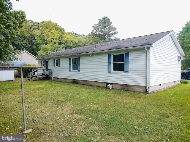 rear view of property featuring a lawn