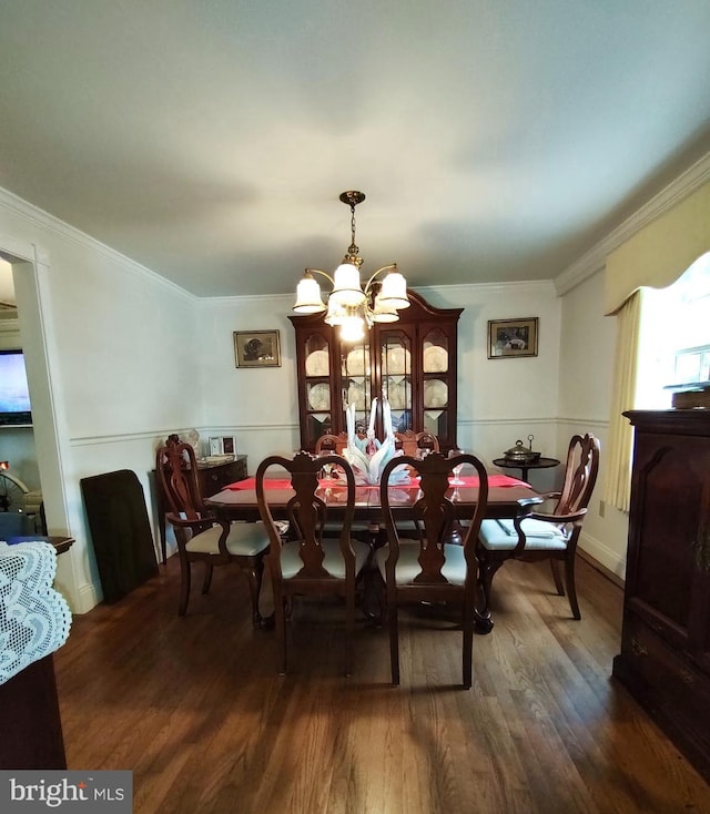 dining room featuring ornamental molding, a chandelier, and dark wood-type flooring