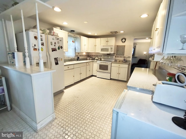 kitchen featuring white cabinets, backsplash, white appliances, kitchen peninsula, and sink