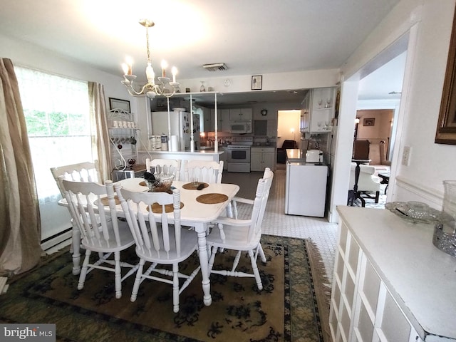 dining space featuring an inviting chandelier, baseboard heating, and dark wood-type flooring