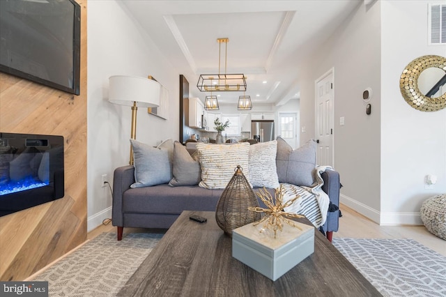 living room with a raised ceiling, ornamental molding, and hardwood / wood-style flooring