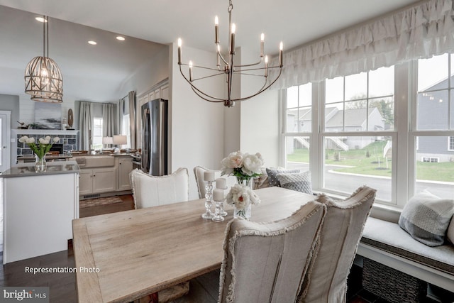 dining area with a notable chandelier, a fireplace, and dark hardwood / wood-style floors