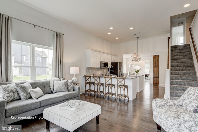 living room with dark hardwood / wood-style floors, a chandelier, and sink