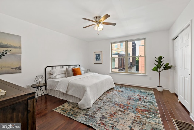 bedroom with a closet, ceiling fan, and dark wood-type flooring