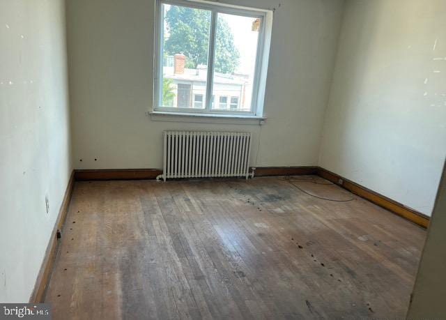 spare room with radiator and hardwood / wood-style floors