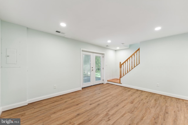 unfurnished room featuring french doors, light wood-type flooring, and electric panel