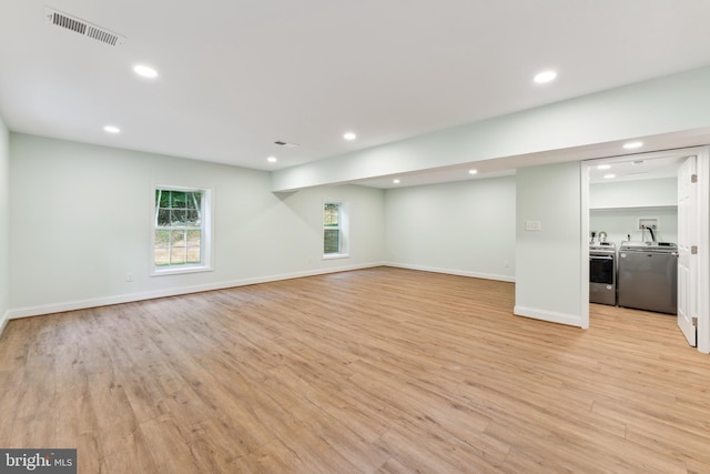 unfurnished living room with light wood-type flooring and washer and clothes dryer