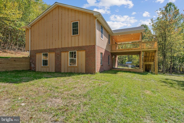 rear view of property featuring a yard and a wooden deck