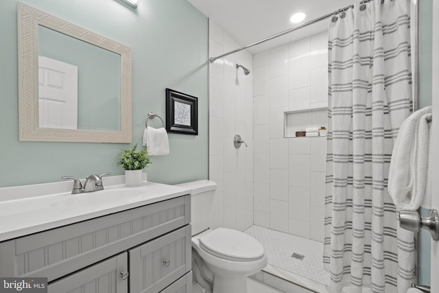 bathroom with vanity, curtained shower, and toilet