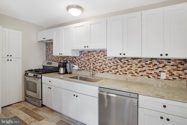 kitchen featuring white cabinets, appliances with stainless steel finishes, sink, and decorative backsplash