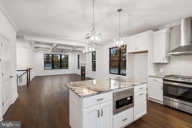 kitchen with appliances with stainless steel finishes, wall chimney exhaust hood, white cabinetry, and dark hardwood / wood-style flooring