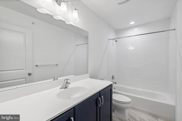 full bathroom with vanity, tiled shower / bath combo, and toilet