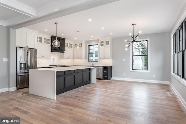 kitchen featuring light hardwood / wood-style flooring, stainless steel appliances, a center island, and hanging light fixtures