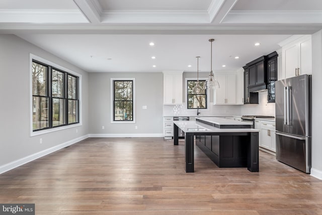 kitchen featuring hanging light fixtures, a kitchen island, appliances with stainless steel finishes, a breakfast bar, and hardwood / wood-style floors