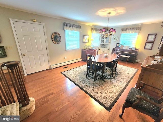 dining area with ornamental molding, a chandelier, light hardwood / wood-style floors, and baseboard heating